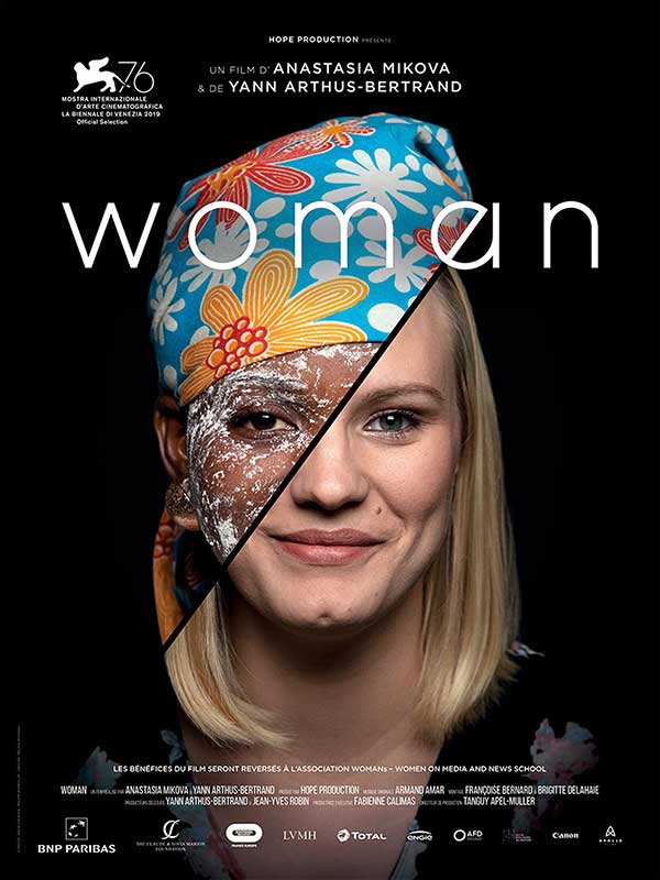 Oficjalny plakat do filmu: głowa kobiety na jednolitym ciemnym zmontowana z dwóch twarzy - afrykanki i europejki . Na zmontowanym obrazie napisy informacyjne dot. filmu. Te same, które podane są w artykule.